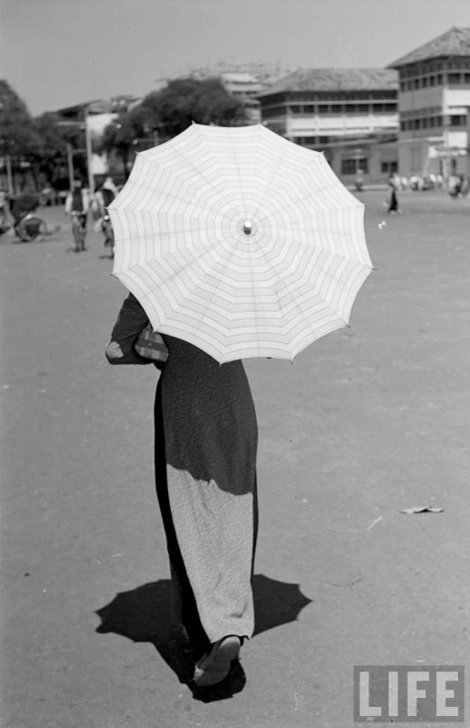 a woman walks down the street holding an umbrella