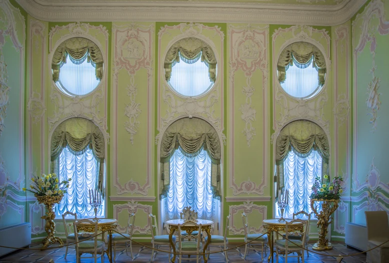 a living room with large windows and gold furniture