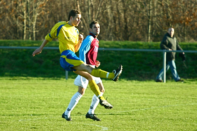 two soccer players playing soccer on a field