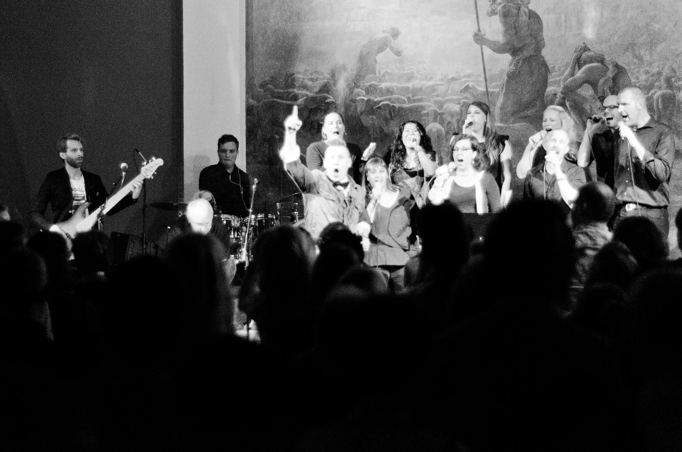 a band singing on stage surrounded by onlookers