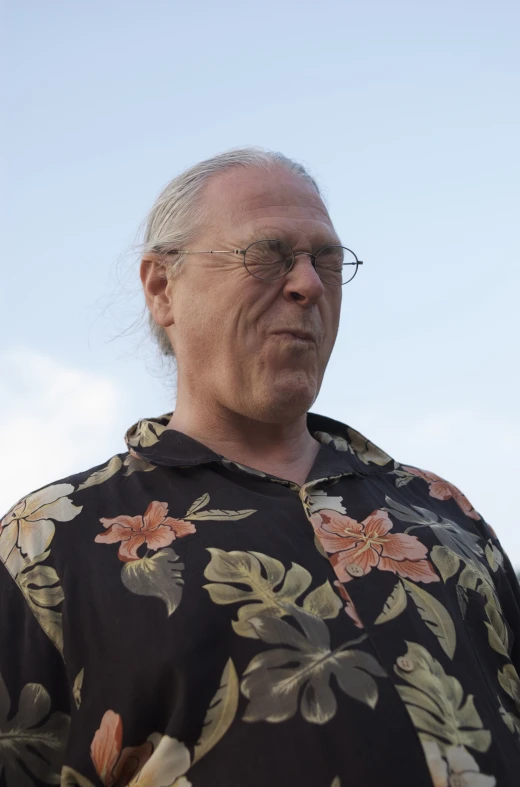 an old man wearing a black shirt with pink flowers