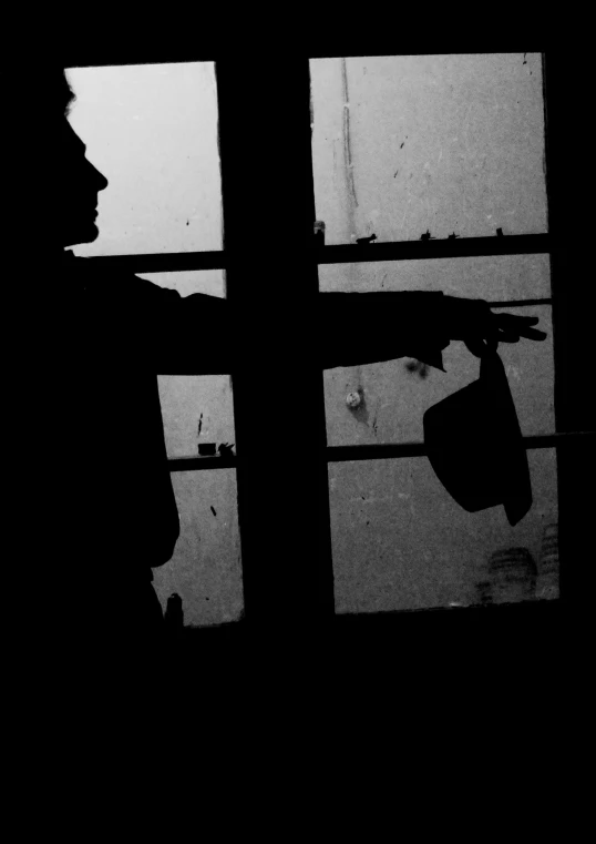 the silhouette of a man in an open window