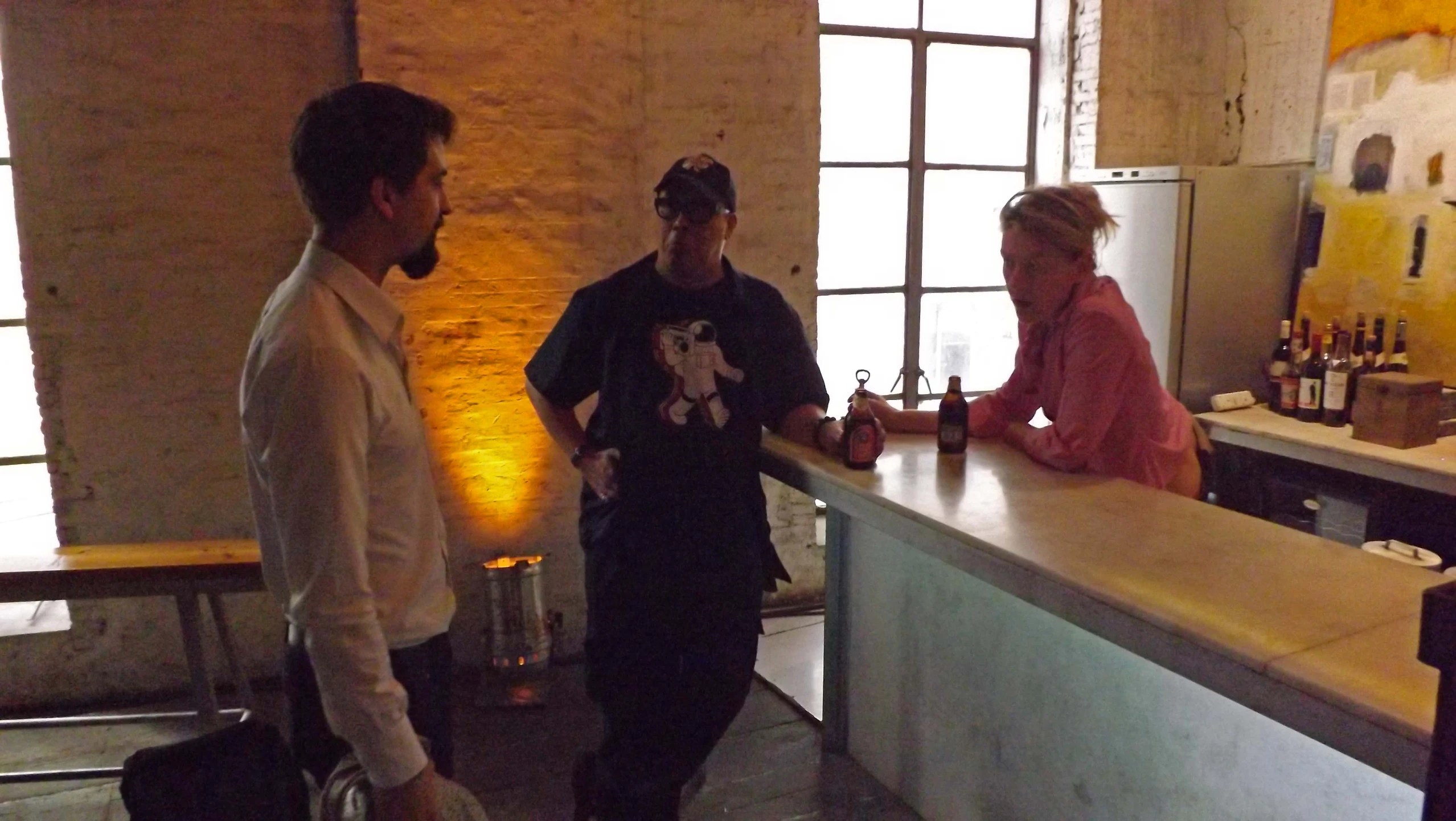 two men and a woman are standing behind the bar