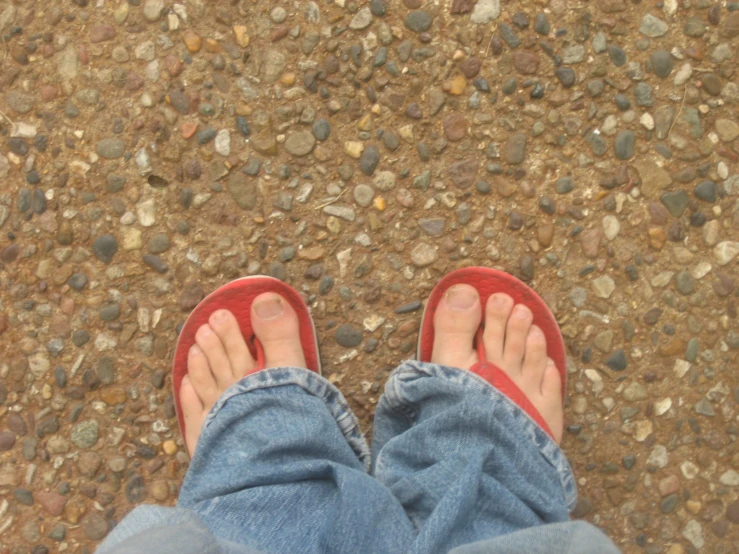 someone is wearing red flip flops while on the street