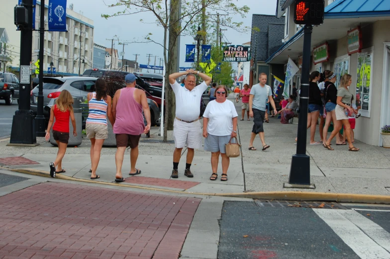 a street scene with people standing on the sidewalk