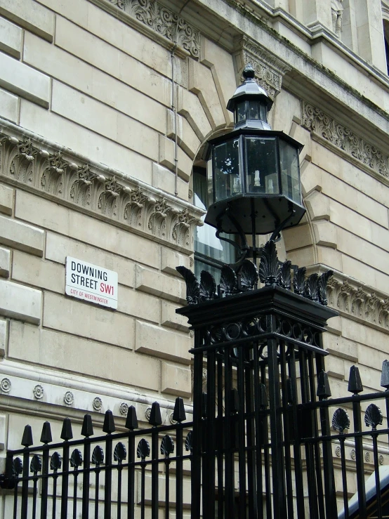 a light pole stands next to a fence and a building