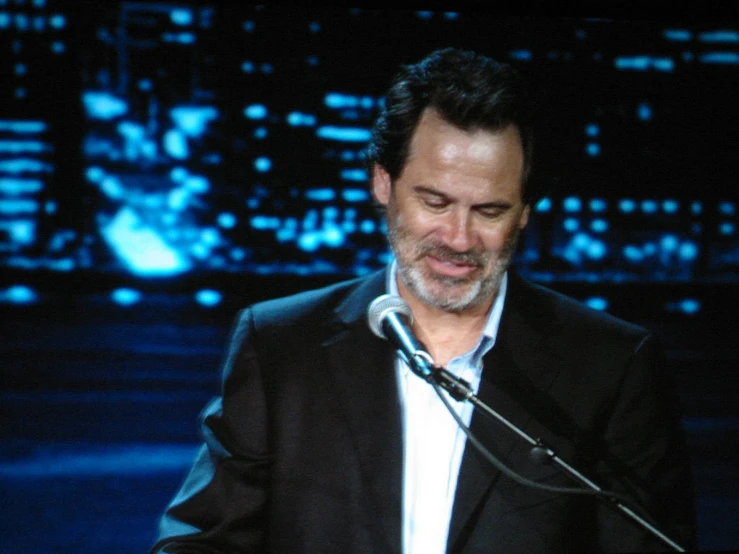 a man in a suit speaking into a microphone