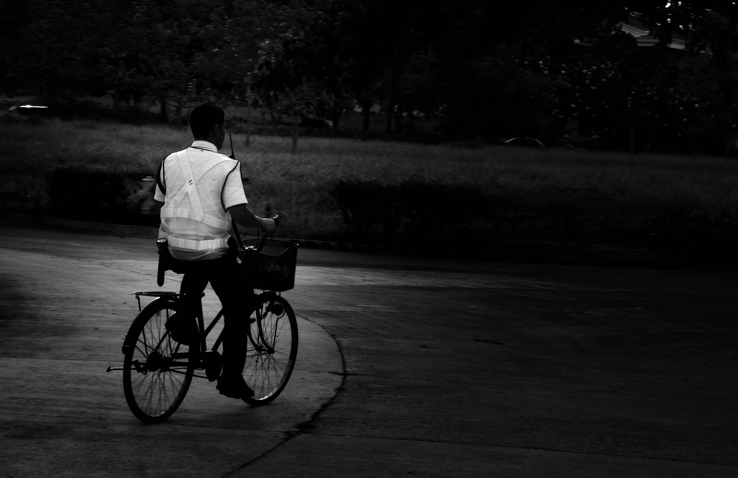 black and white pograph of a man riding a bicycle