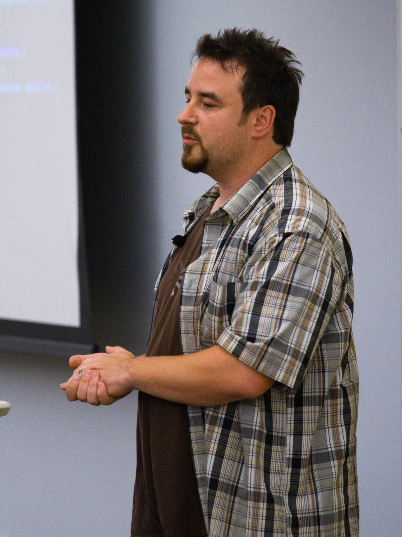 a man is giving a presentation while standing in front of a screen