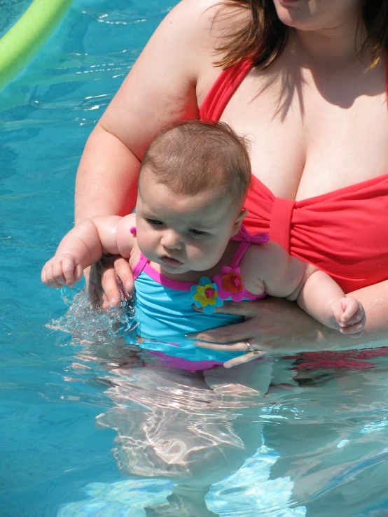 there is a woman holding a baby in the water