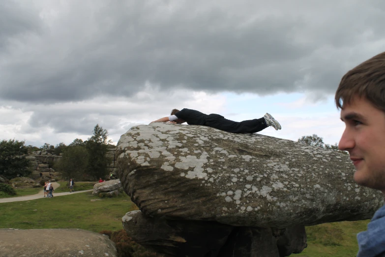 a man resting on top of a large rock