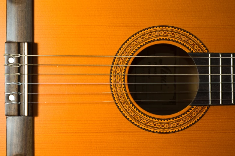 an orange acoustic guitar sitting close up to the neck