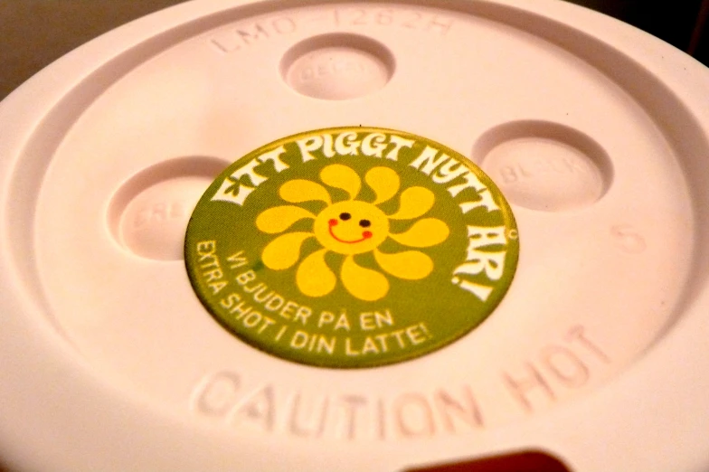 the bottom of a coffee cup with a sticker on it