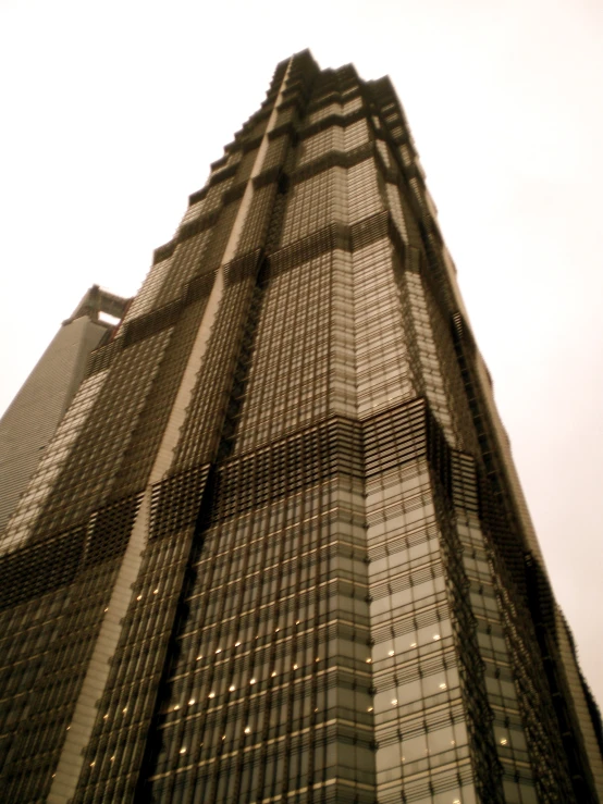 a high building with many windows with a cloudy sky behind it
