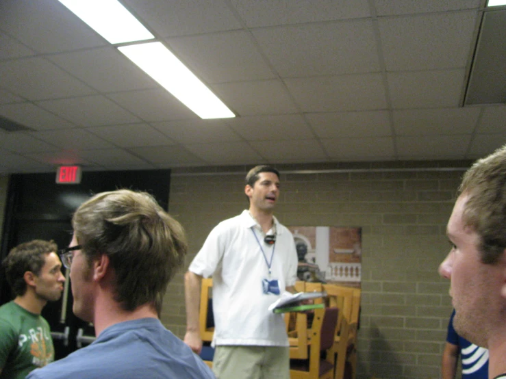 four men in a room with one on a video game controller