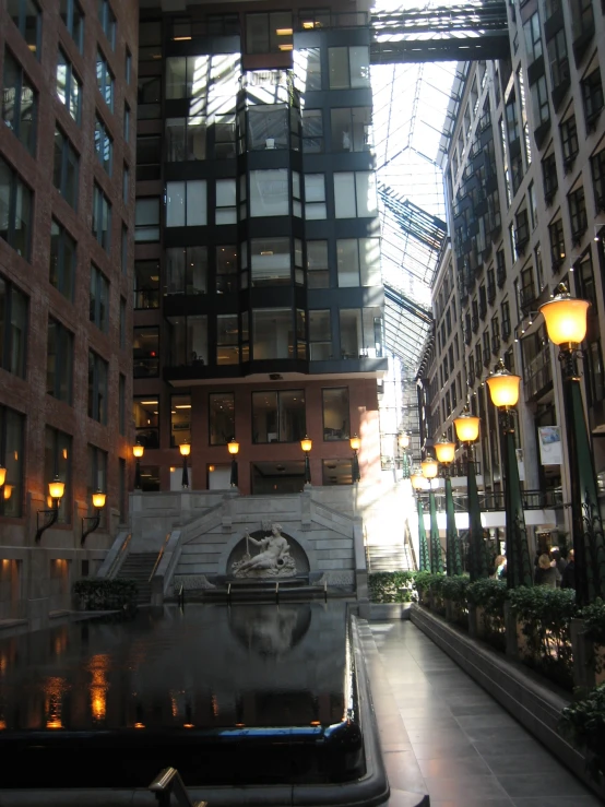 the walkway leads to a fountain near two buildings