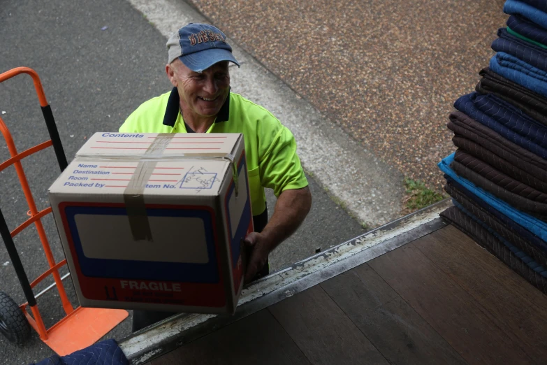 a man holding boxes with a hand cart next to some stairs