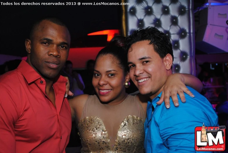 three people posing for a po at a nightclub