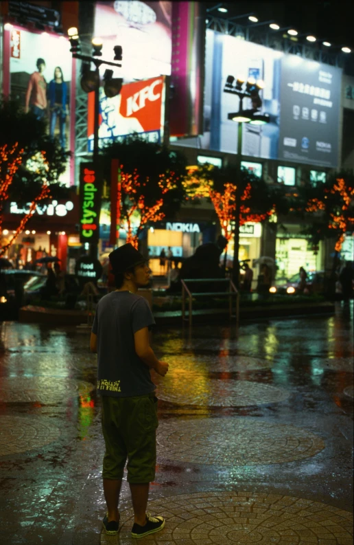 boy on rainy sidewalk near street and buildings