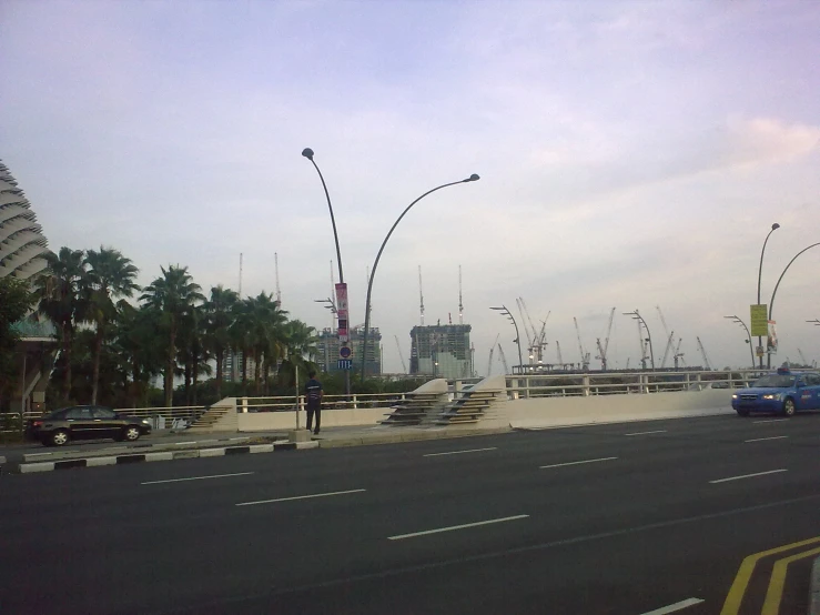 a road with vehicles going down it next to tall buildings