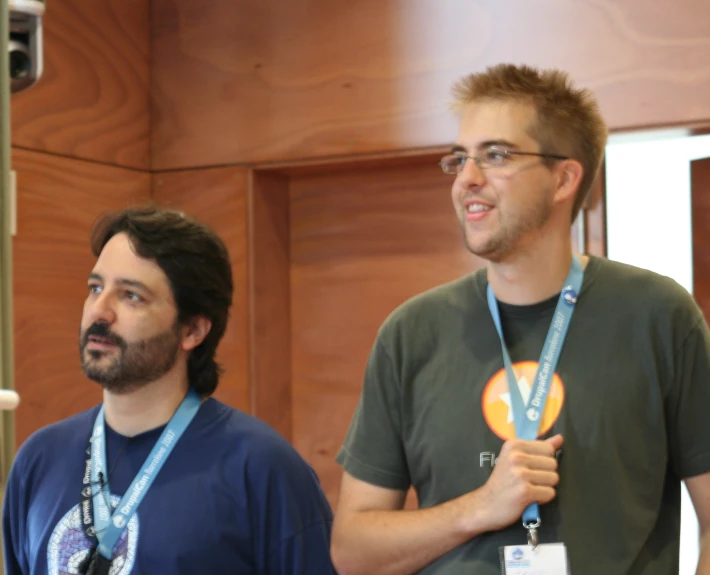 a man in blue shirt with two other men standing