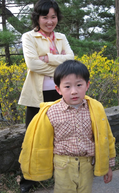  in yellow jacket and woman standing behind him