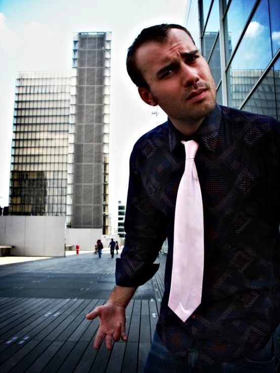 a man wearing a white tie outside near skyscrs