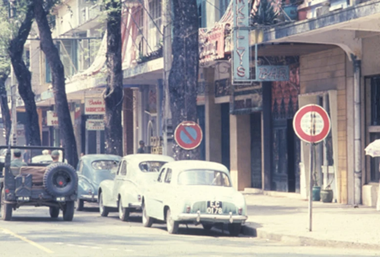 old car sitting on street beside another vintage car