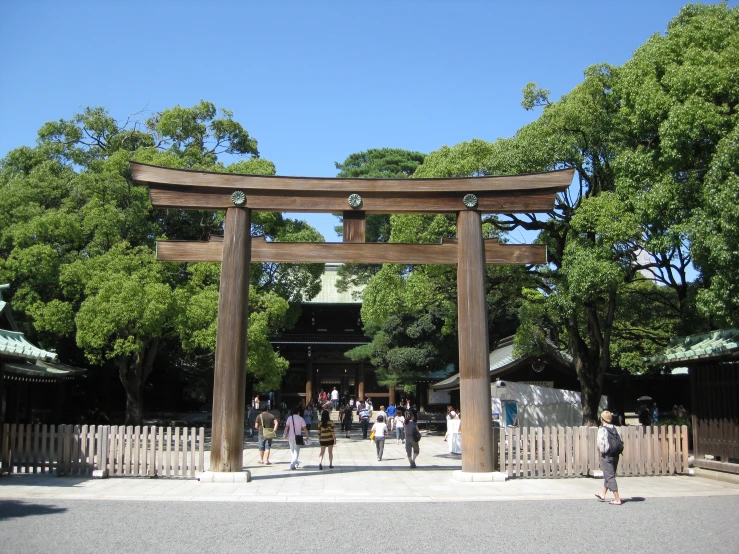 people standing in front of a tall wooden gate