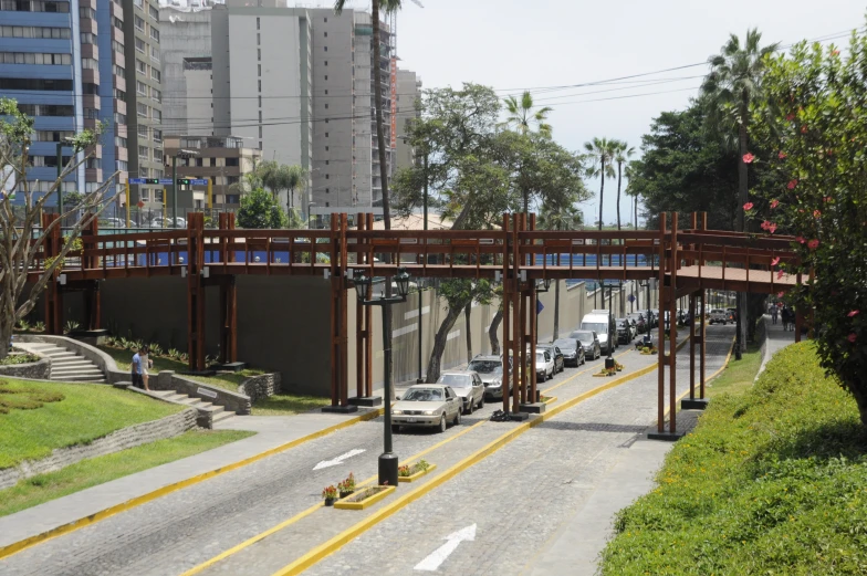 some cars on a city street with a bridge above them