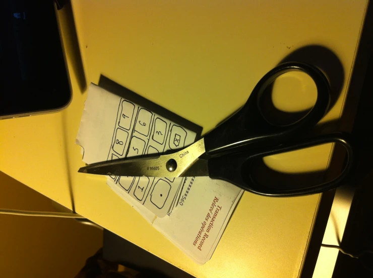 a pair of scissors and a paper on top of a desk