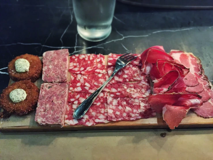 a plate topped with sliced meat and potatoes on a table