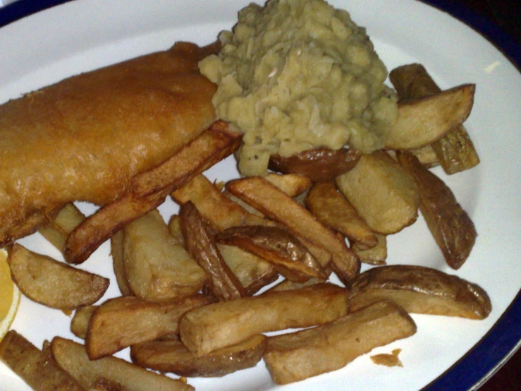 a plate with french fries, coleslaw and gravy on it