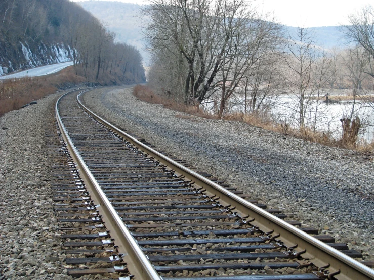 the railroad tracks run through a field near the water