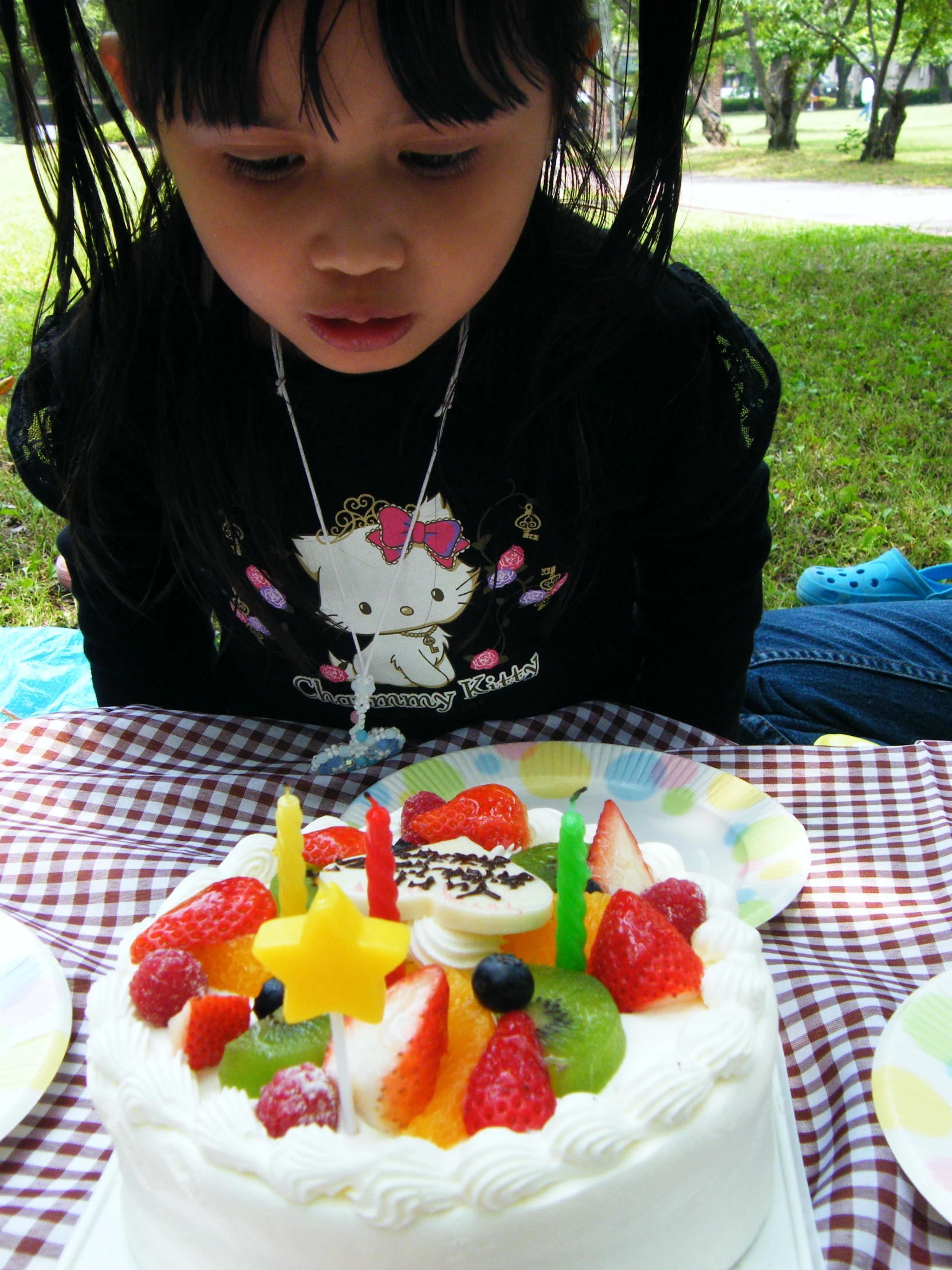 the little girl is sitting in front of her birthday cake