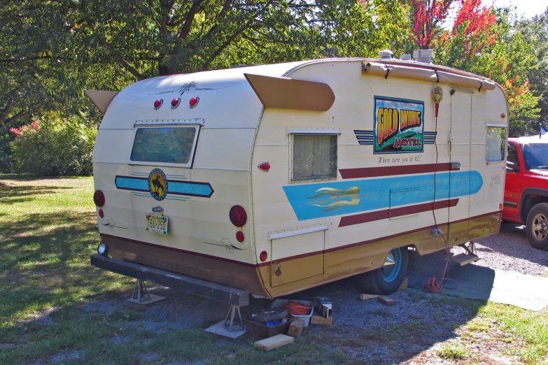 an old travel trailer sits parked in the grass