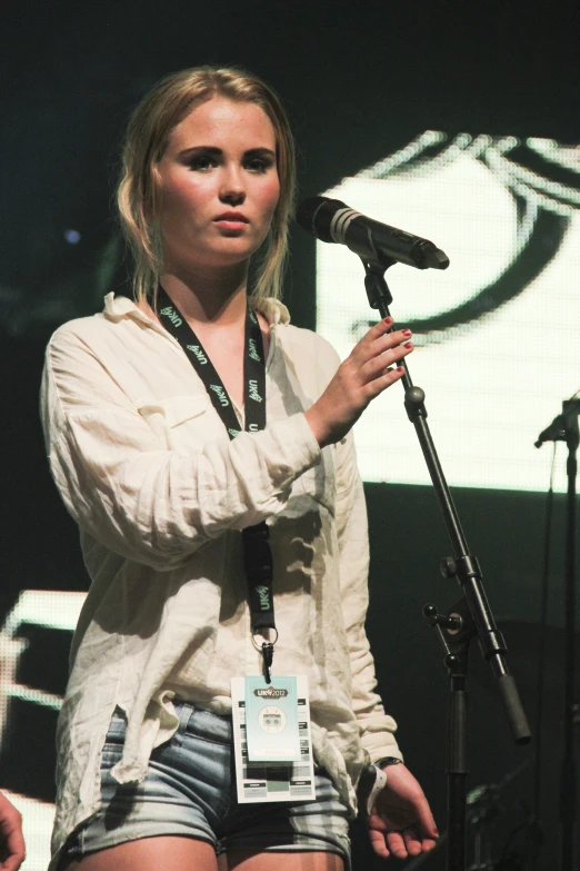 a girl with short shorts standing near microphone