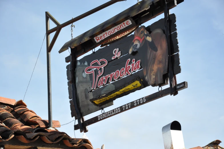 the large sign is posted high above a roof