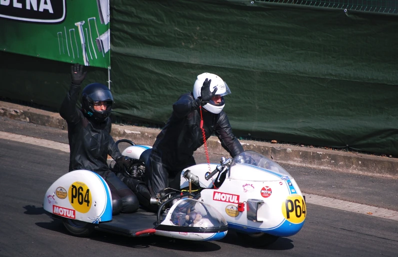 two people riding on a motorcycle on the street