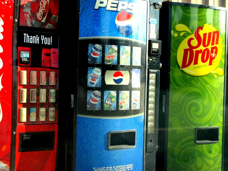 coca - cola machines lined up next to each other