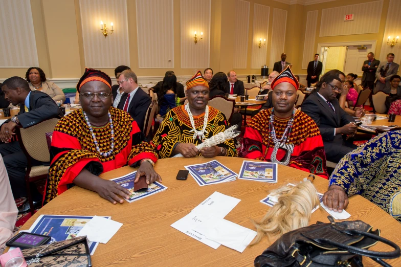 some people are sitting at a round table and some have pictures on it