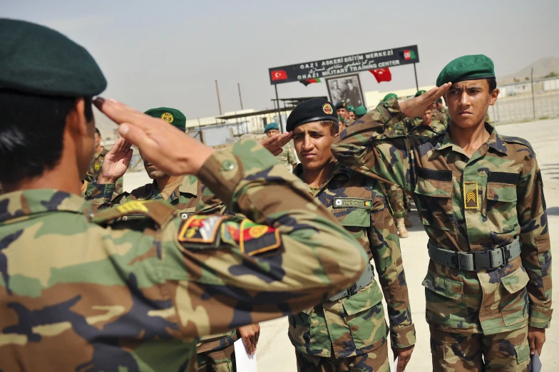 soldiers saluting on the road while two men are taking pictures