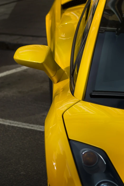 a bright yellow sports car's wing mirror