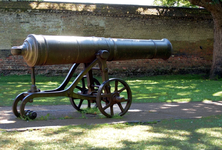 an old cannon in front of a brick wall