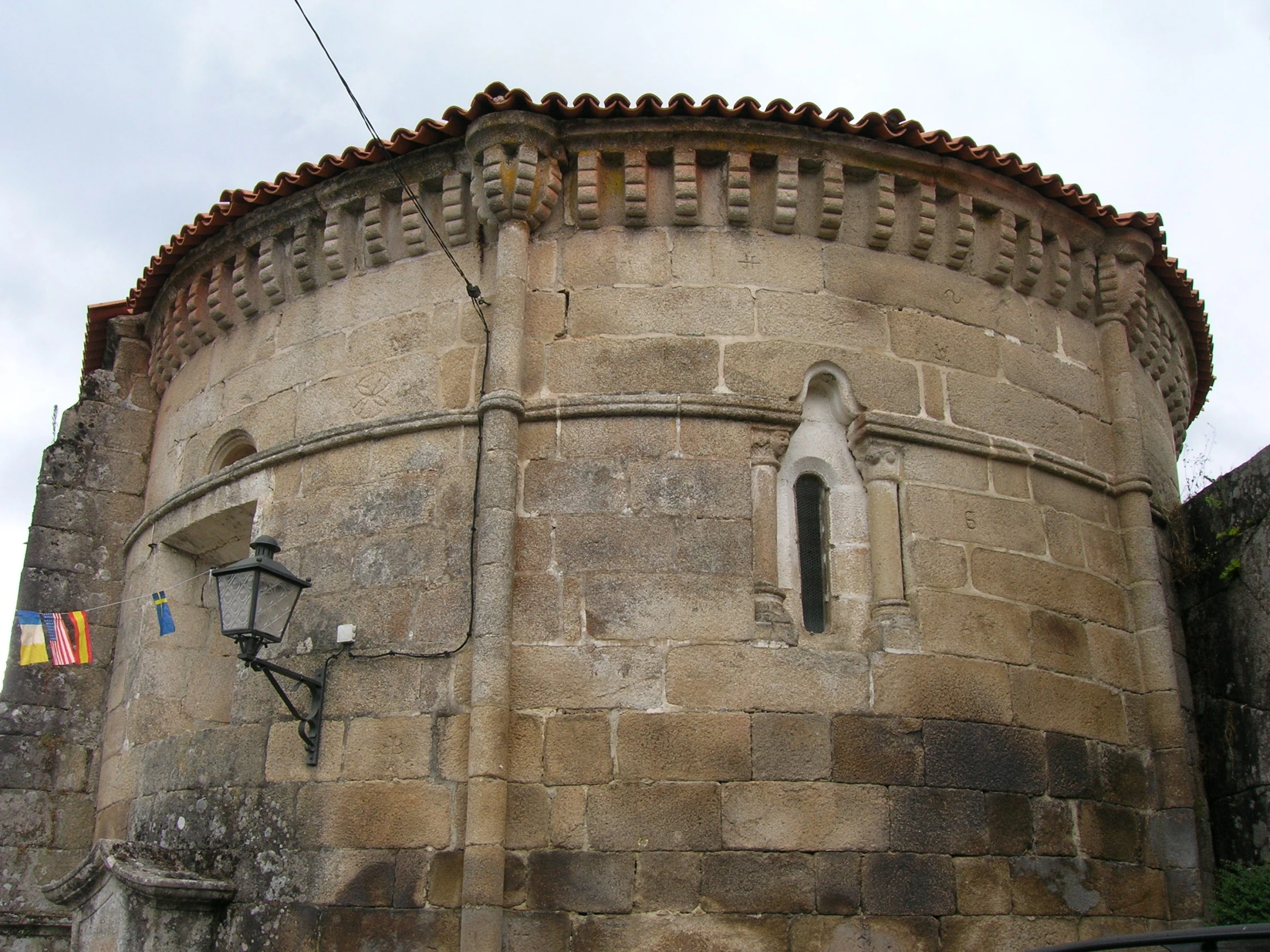 a building made of old bricks with a window and a street lamp on the corner