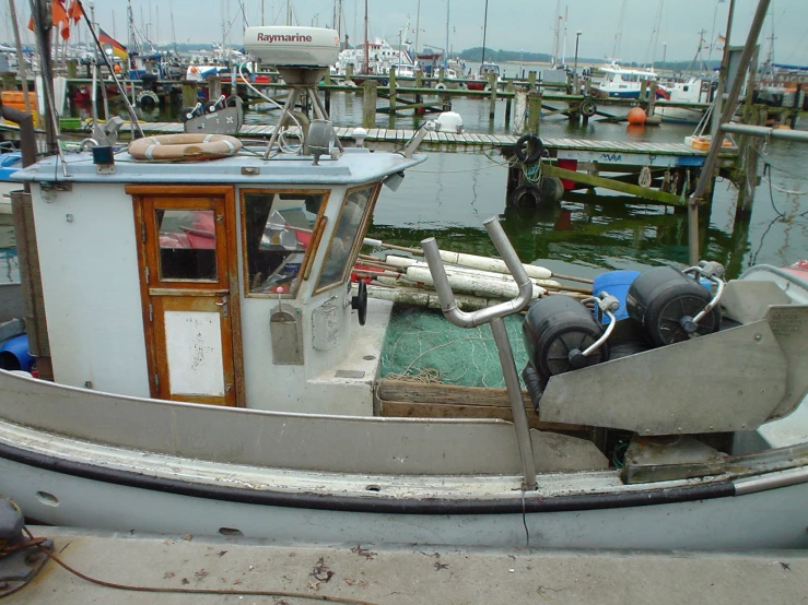 a white boat with three oars sitting in a harbor