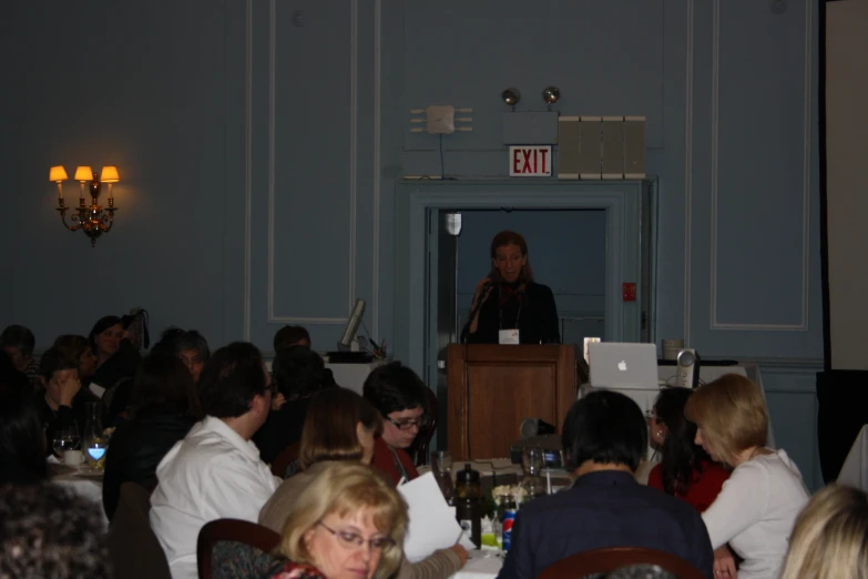 an event with many people and speakers and people sitting at tables