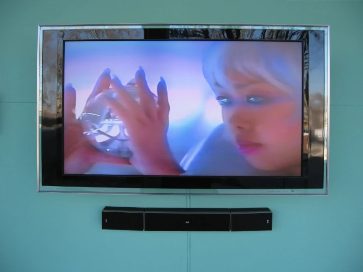 a wall mounted television above a shelf filled with electronics