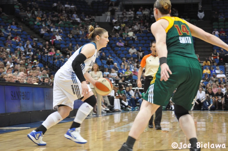 a lady playing basketball in a sports stadium