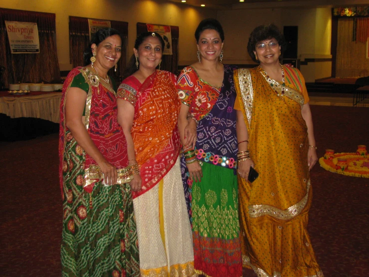 some ladies are posing for a po while dressed in bright sari